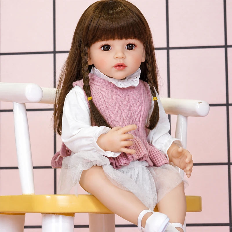 Lifelike reborn doll featuring expressive brown eyes, delicate lashes, softly blushed cheeks, pink lips, and braided brown hair.