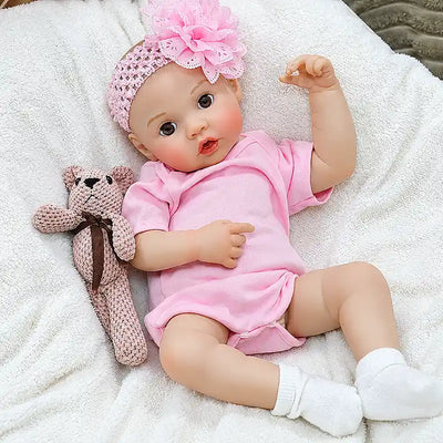Adorable reborn baby doll relaxing on a fluffy blanket, perfect for bottle-feeding play, pretend parenting, storytime, and family photos.