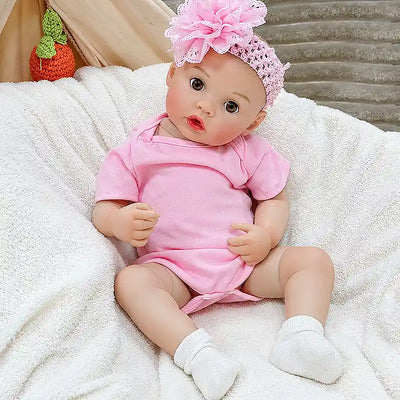 Maisie is ready for bottle time, cuddles, bedtime routines, and nursery play, featuring a sweet baby expression, detailed fingers, and a charming pink outfit.