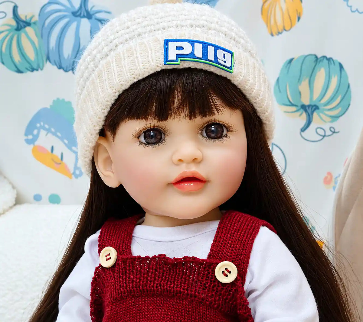 Cute Charlotte doll dressed in a red knitted romper and white hat, ideal for pretend feeding, playroom adventures, bedtime routines, and nurturing role play.