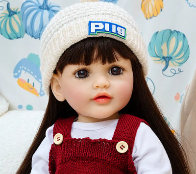 Cute Charlotte doll dressed in a red knitted romper and white hat, ideal for pretend feeding, playroom adventures, bedtime routines, and nurturing role play.
