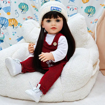 Realistic reborn doll Charlotte wearing floral red knit overalls, a cozy white beanie, and tiny white shoes, perfect for cuddles, pretend play, and nursery display.