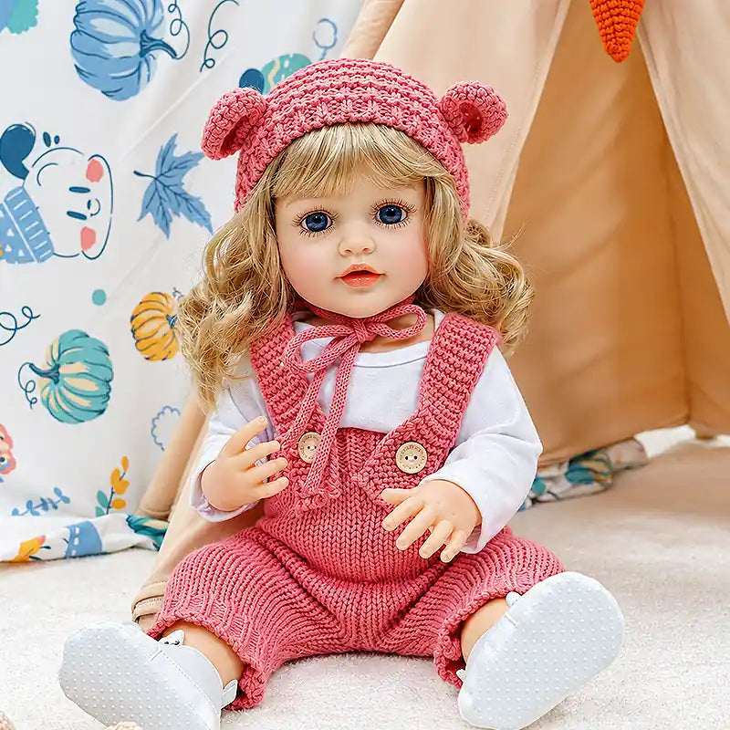 Sweet reborn girl doll Isabella relaxing on a fluffy blanket with her favorite teddy bear, ready for bedtime stories, tea parties, and imaginative family play.