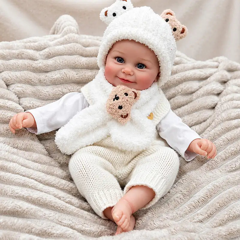 Cheerful Reborn Baby Doll Wearing a Fluffy Bear Hat, Scarf and Knitted Trousers