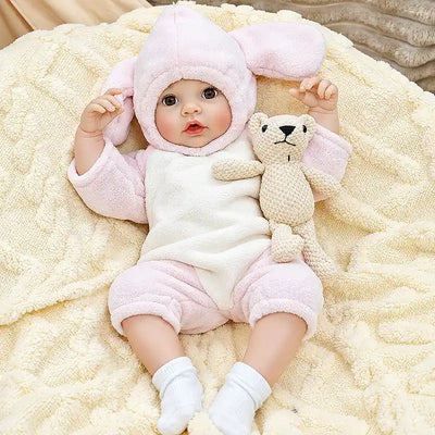 Detailed reborn baby doll Ella featuring a sweet open-eyed expression, rosy cheeks, delicate fingers, cozy pink clothing, and a bottle-feeding feature for collectors and gift giving.