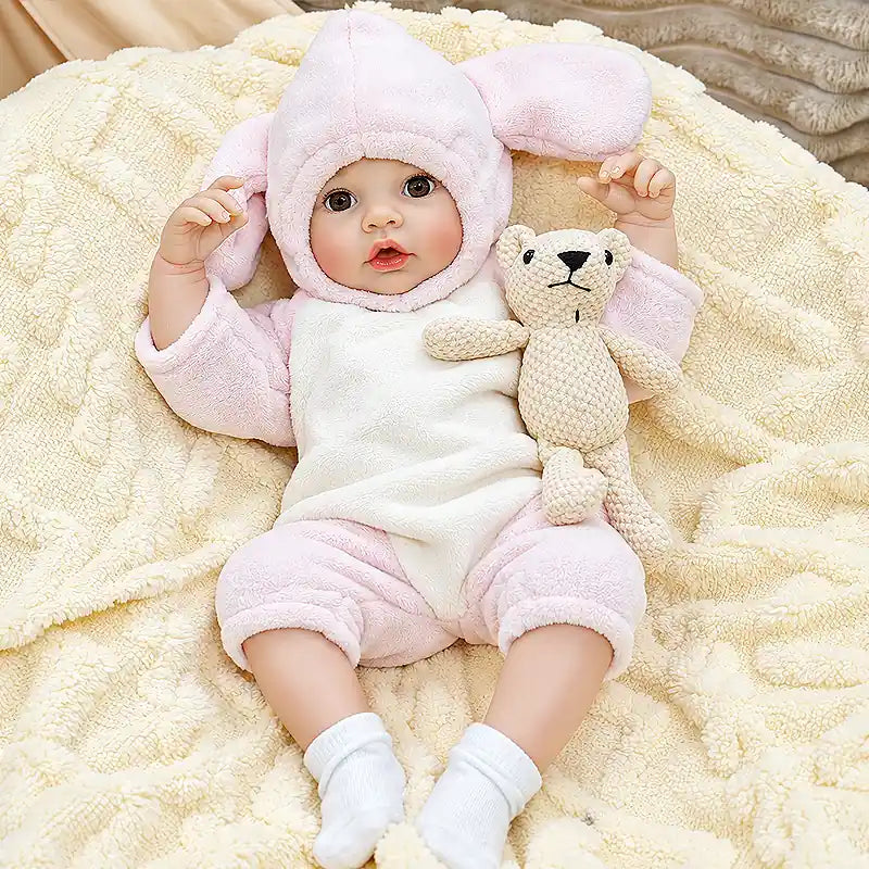 Detailed reborn baby doll Ella featuring a sweet open-eyed expression, rosy cheeks, delicate fingers, cozy pink clothing, and a bottle-feeding feature for collectors and gift giving.