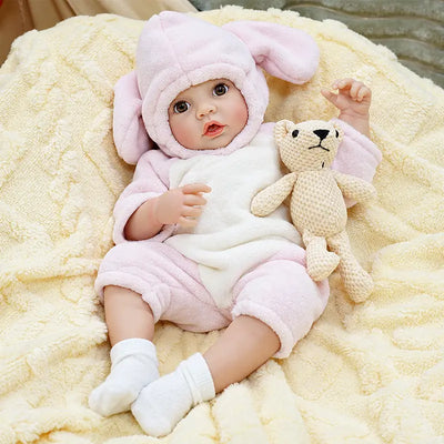 Ella features bright brown eyes, glossy lips, natural baby coloring, detailed hands and feet, and carefully crafted reborn details for an engaging feeding experience.