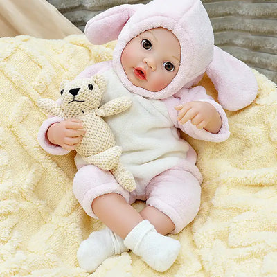 Ella wears a fluffy pink bunny suit and enjoys feeding time, making her perfect for children’s nurturing play, bedtime routines, nursery photos, and cuddles.