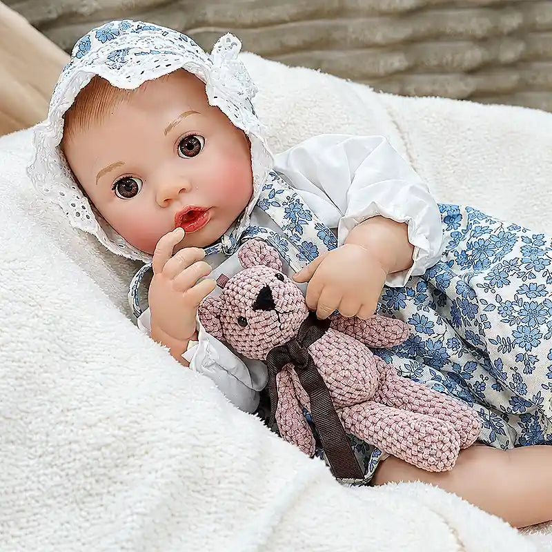 Bottle-feeding Ellis brings everyday caregiving to life with realistic baby details, a cute seated pose, delicate fingers, and a playful teddy bear companion.