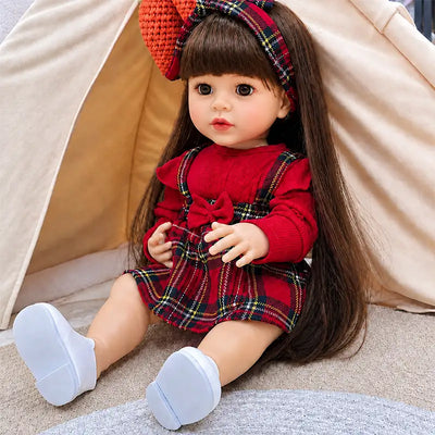 Beautiful reborn girl doll with silky brown hair, realistic eyelashes, rosy cheeks, detailed fingers, white shoes, and a classic tartan outfit.