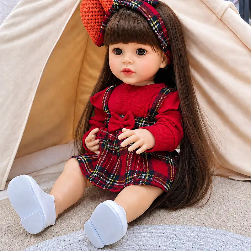 Beautiful reborn girl doll with silky brown hair, realistic eyelashes, rosy cheeks, detailed fingers, white shoes, and a classic tartan outfit.