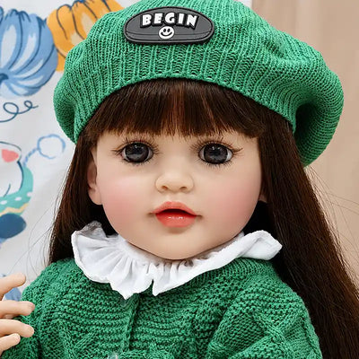Amelia reborn baby doll with rosy cheeks, glossy lips, soft facial details, and handmade green knit clothing, perfect for pretend play, cuddles, and doll collections.