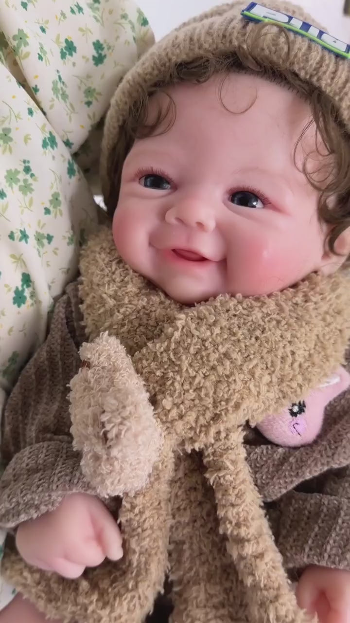 Load video: Full Silicone Reborn Baby Doll with Bright Blue Eyes, Curly Hair, Rosy Cheeks, and Tiny Hands