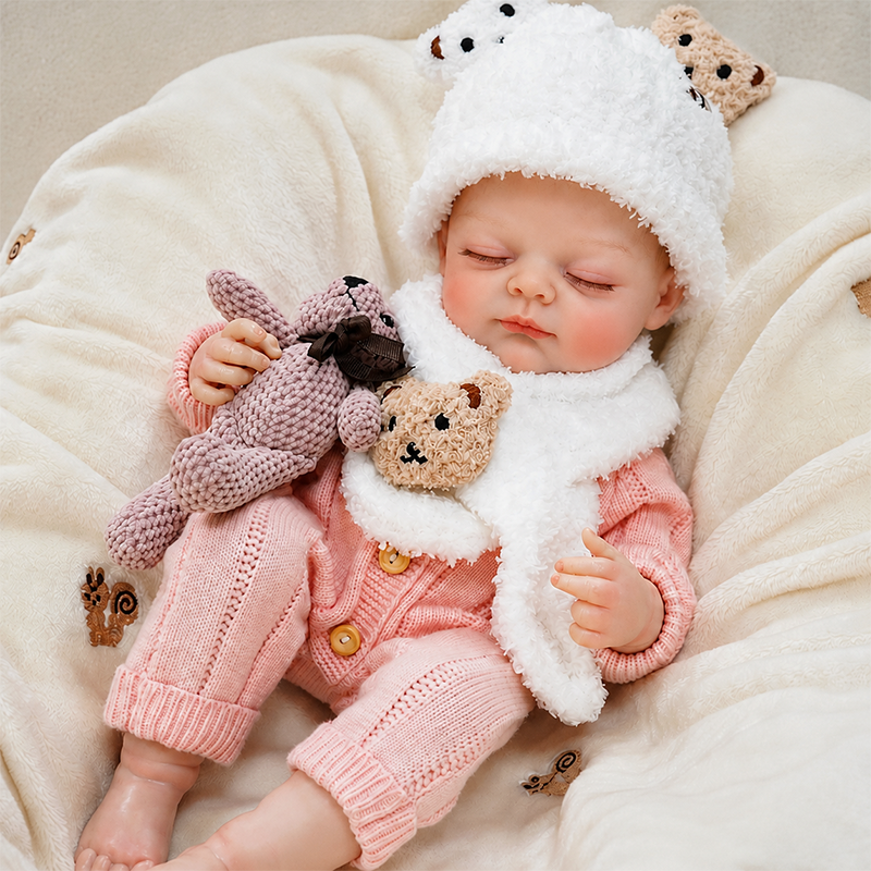 Cozy sleeping reborn baby doll cuddled with a plush bunny on a soft cream blanket, perfect for a warm nursery or holiday gift setting.