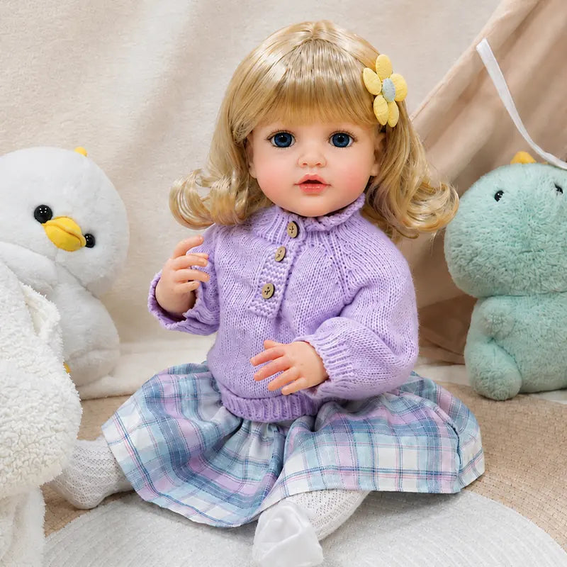 Beautiful blonde reborn collectible doll with expressive blue eyes, curled hair, realistic facial coloring, and charming European-inspired outfit.