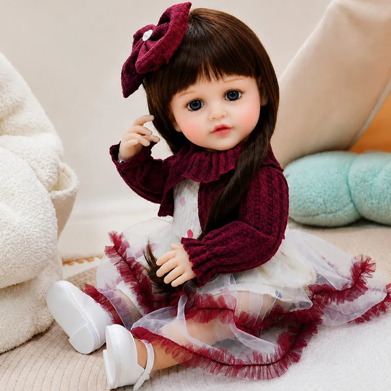 Lifelike reborn doll dressed in a burgundy outfit