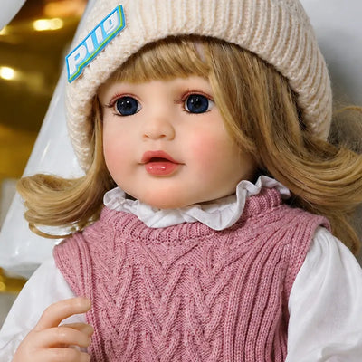 Lifelike reborn toddler doll with realistic facial details, bright blue eyes, blonde hair, and a sweet rosy-cheeked expression.