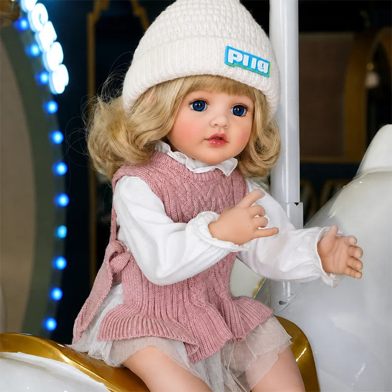 Reborn girl doll featuring sparkling blue eyes, delicate eyelashes, soft blonde curls, natural rosy cheeks, and glossy pink lips.