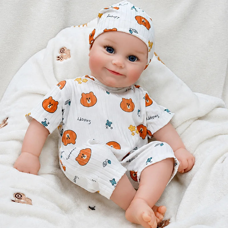 Close-detail reborn doll with sparkling blue eyes, delicate eyelashes, soft eyebrows, rosy cheeks, a tiny nose, and naturally colored lips.