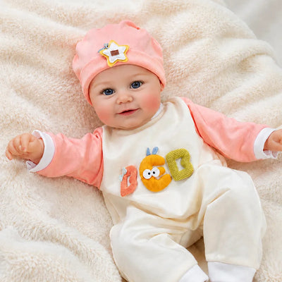 Adorable reborn baby doll for children, reborn doll collectors, and gift shoppers, dressed in a cozy peach-and-cream outfit for birthdays and Christmas.